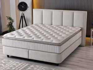 Chole boxspring in crèmekleurige stof met hoog hoofdbord met vijf panelen